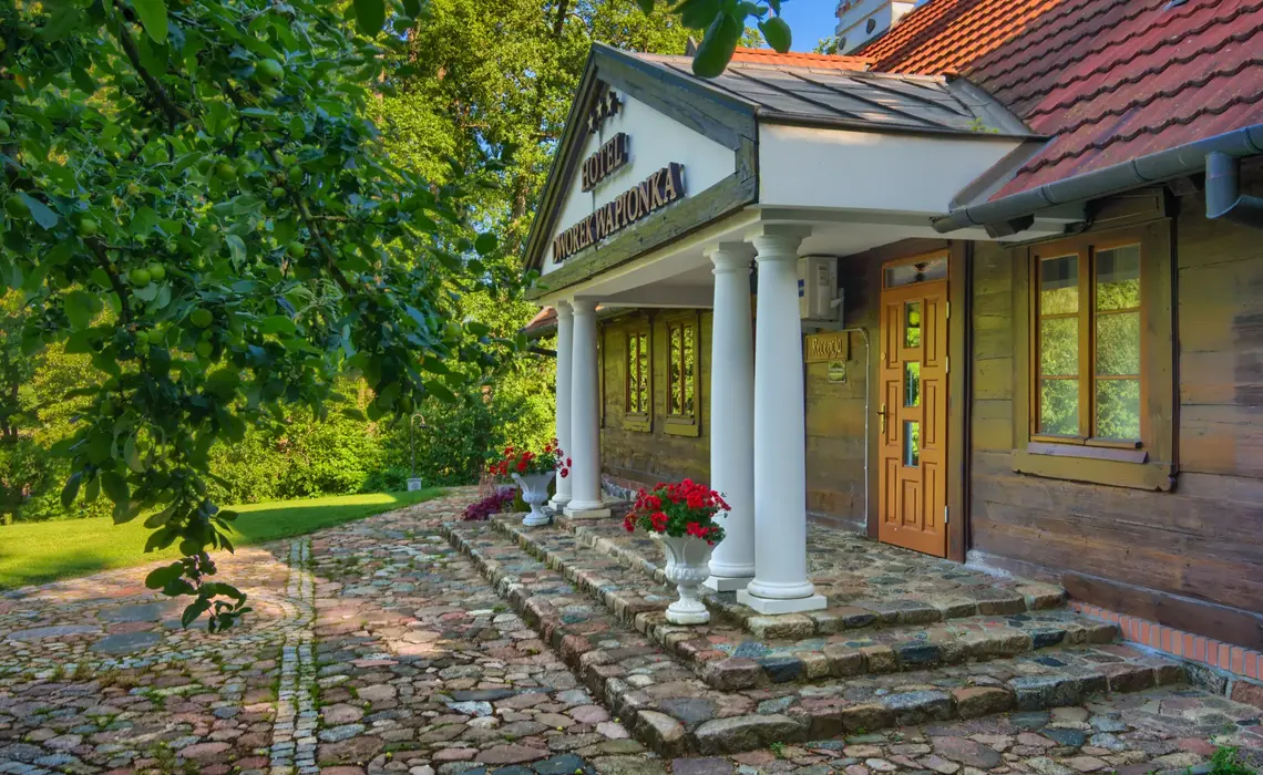 Historisch gebouw van Hotel Dworek Wapionka te midden van groen